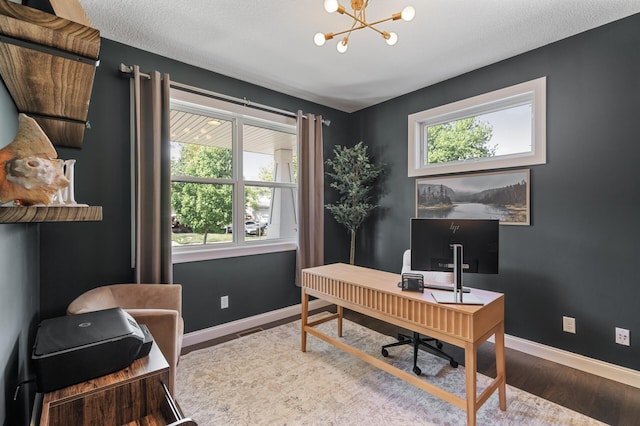 office featuring plenty of natural light, wood finished floors, a chandelier, and baseboards