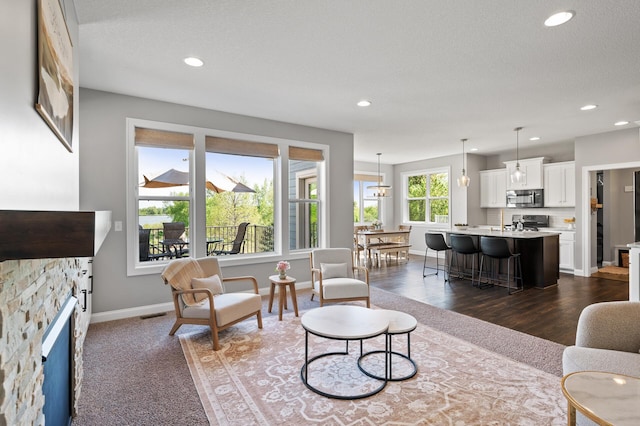 living room featuring a fireplace, recessed lighting, baseboards, and dark wood-style floors