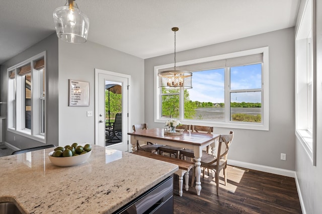dining area with plenty of natural light, dark wood-type flooring, baseboards, and a chandelier