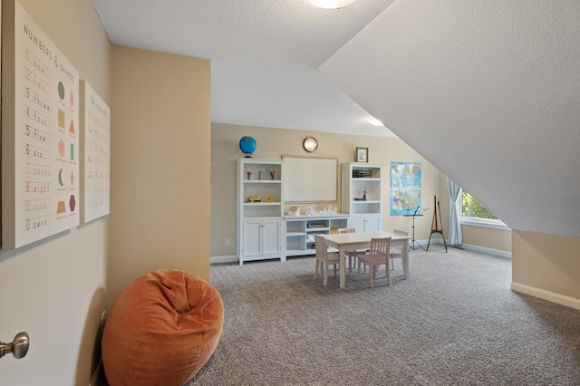 dining room featuring lofted ceiling, carpet floors, a textured ceiling, and baseboards