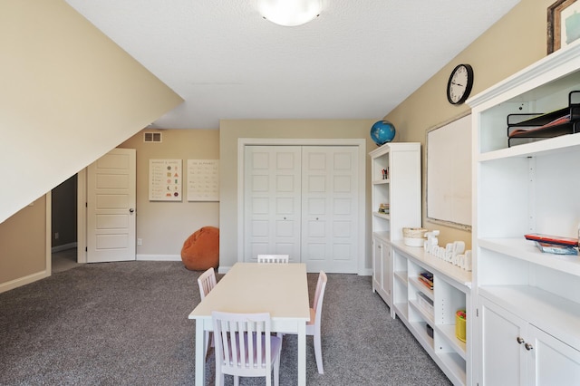 playroom featuring carpet floors, baseboards, and a textured ceiling