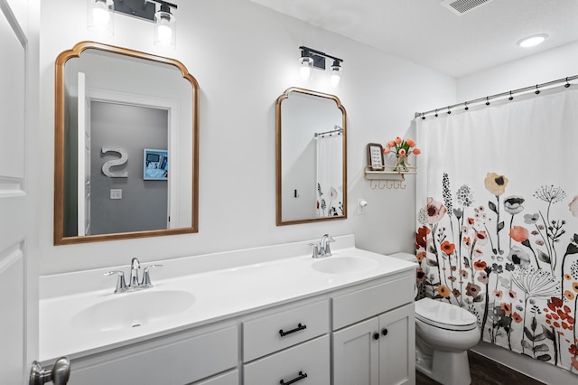 full bath with double vanity, toilet, and a shower with shower curtain