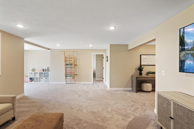 living area featuring light carpet, recessed lighting, a textured ceiling, and baseboards