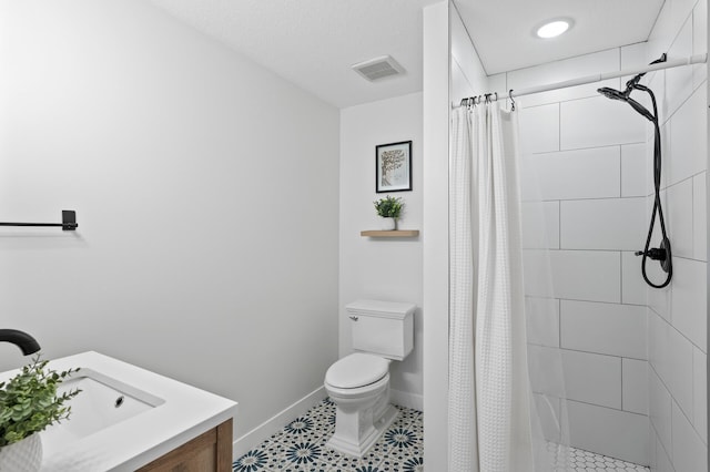full bath with toilet, a sink, a stall shower, and baseboards