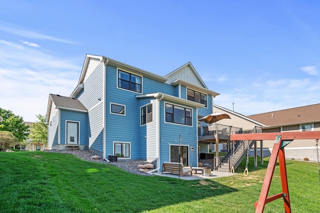 rear view of property with stairs, a deck, a patio area, a yard, and board and batten siding