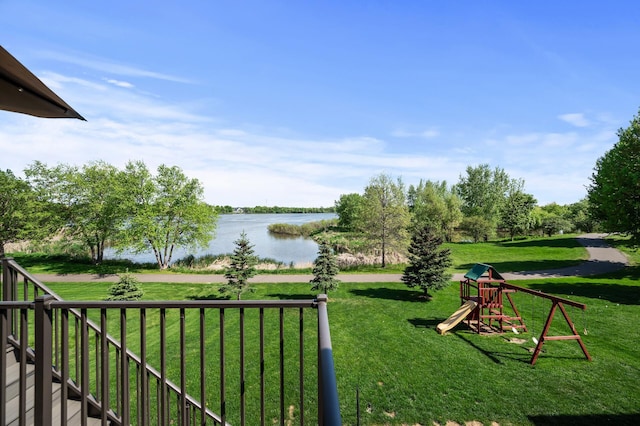 view of property's community with a water view, a playground, and a yard