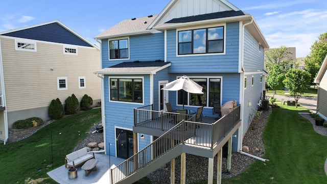 rear view of property featuring cooling unit, a yard, board and batten siding, and a deck
