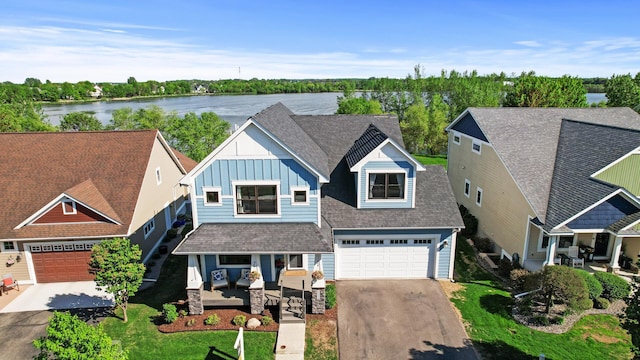 view of front of home featuring asphalt driveway, a porch, board and batten siding, and a water view