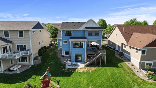 6644 Lamplight Dr, Albertville, MN 55301 - back of house featuring board and batten siding, a patio, a residential view, and a lawn