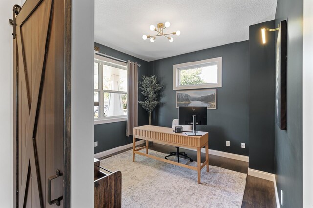 6644 Lamplight Dr, Albertville, MN 55301 - office area featuring plenty of natural light, wood finished floors, a chandelier, baseboards, and a textured ceiling