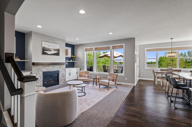 6644 Lamplight Dr, Albertville, MN 55301 - living area with plenty of natural light, a stone fireplace, a textured ceiling, recessed lighting, and dark wood-style flooring