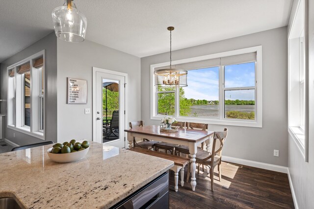 6644 Lamplight Dr, Albertville, MN 55301 - dining space with plenty of natural light, dark wood finished floors, baseboards, and a chandelier