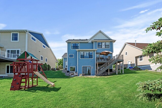6644 Lamplight Dr, Albertville, MN 55301 - rear view of property with board and batten siding, a lawn, a deck, stairs, and a playground
