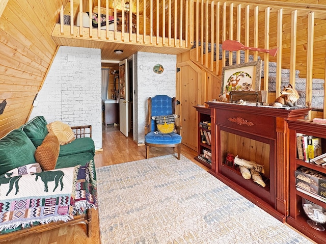 sitting room featuring wood finished floors, wooden walls, and wooden ceiling