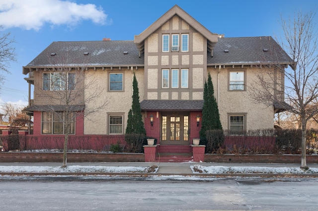 view of front of home with a fenced front yard, stucco siding, and french doors