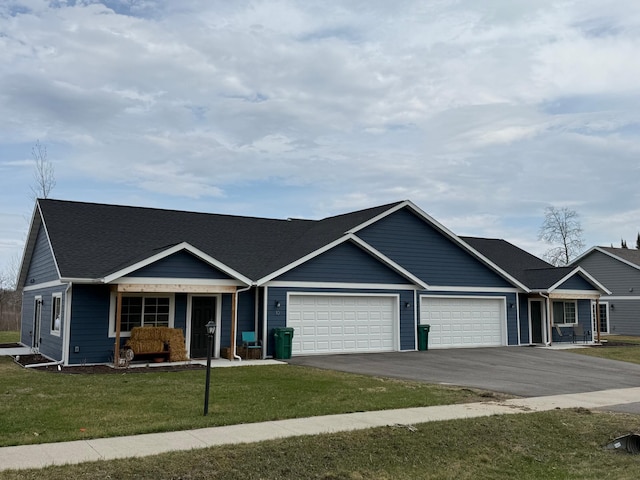 6809 Hamilton Park NW Unit 11, Bemidji, MN 56601 - view of front of house featuring a garage, asphalt driveway, a front yard, and covered porch