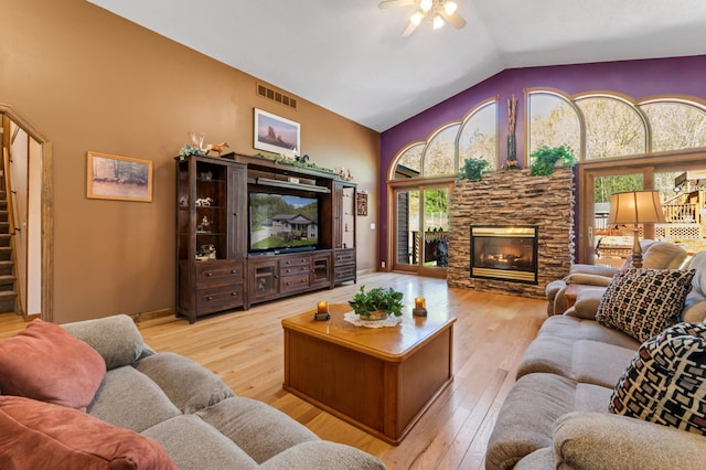23677 County Road 23, Winona, MN 55987 - living room featuring a ceiling fan, a fireplace, wood finished floors, stairway, and high vaulted ceiling