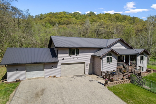 23677 County Road 23, Winona, MN 55987 - view of front facade with asphalt driveway, a view of trees, metal roof, a porch, and an attached garage