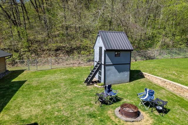 23677 County Road 23, Winona, MN 55987 - view of yard featuring a fire pit, a storage unit, an outbuilding, and a view of trees