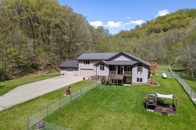 23677 County Road 23, Winona, MN 55987 - view of front of home with a wooded view, a garage, concrete driveway, and a wooden deck