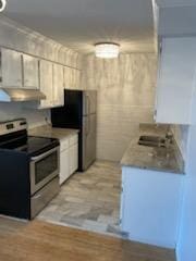7412 22nd St Unit 204, Saint Louis Park, MN 55426 - kitchen with appliances with stainless steel finishes, under cabinet range hood, white cabinets, and light countertops