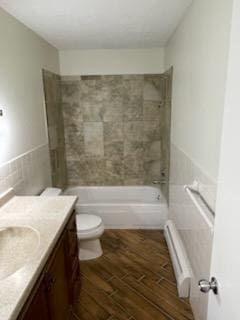 7412 22nd St Unit 204, Saint Louis Park, MN 55426 - bathroom featuring wood finished floors, toilet, vanity, a baseboard radiator, and washtub / shower combination