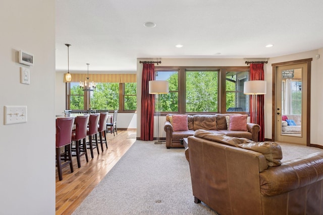 living room featuring healthy amount of natural light, wood finished floors, a chandelier, recessed lighting, and baseboards