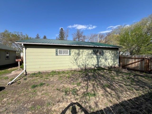 view of home's exterior featuring fence and metal roof