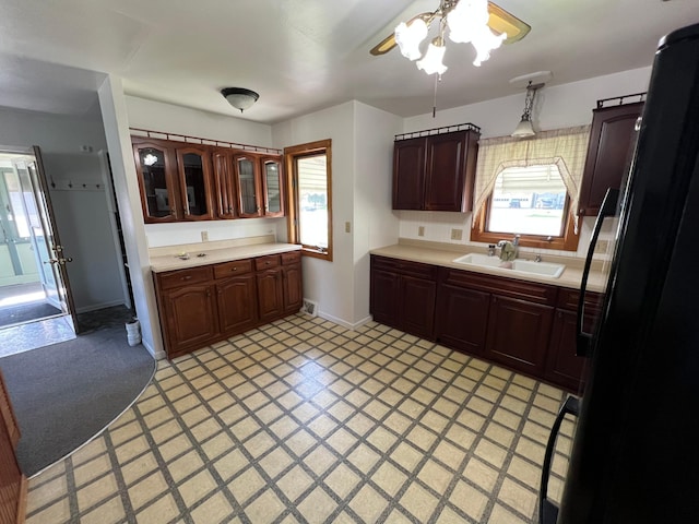 kitchen with a sink, light countertops, ceiling fan, and healthy amount of natural light
