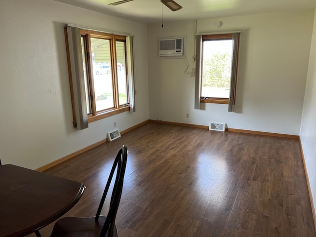 unfurnished dining area featuring a wall unit AC, wood finished floors, a ceiling fan, and baseboards