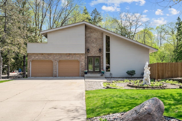 2209 Indian Rd W, Minnetonka, MN 55305 - mid-century inspired home featuring an attached garage, driveway, brick siding, and french doors