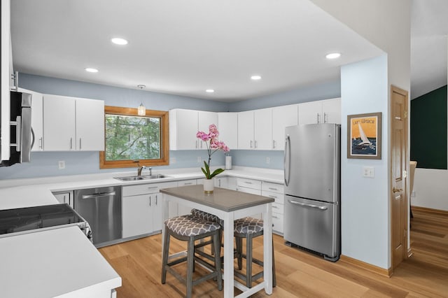 2209 Indian Rd W, Minnetonka, MN 55305 - kitchen with stainless steel appliances, light wood-style flooring, white cabinets, a sink, and recessed lighting
