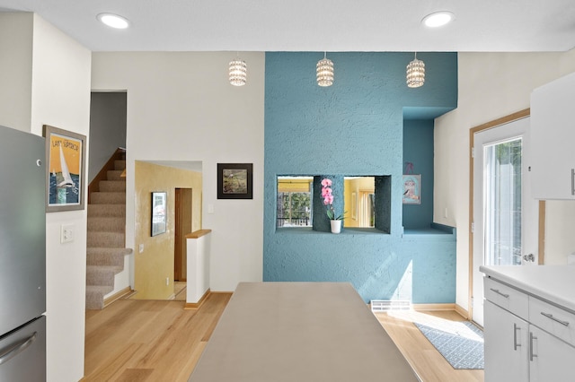 2209 Indian Rd W, Minnetonka, MN 55305 - hallway with light wood-style flooring, stairs, recessed lighting, and a textured wall