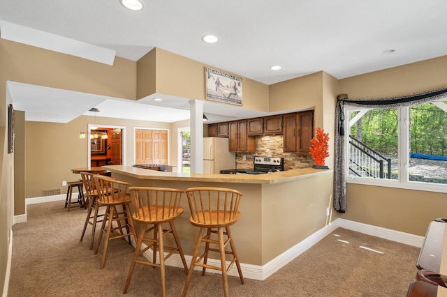2209 Indian Rd W, Minnetonka, MN 55305 - kitchen with freestanding refrigerator, light carpet, range with electric cooktop, baseboards, and tasteful backsplash