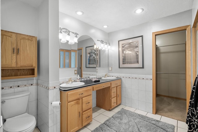 2209 Indian Rd W, Minnetonka, MN 55305 - full bathroom featuring tile walls, tile patterned flooring, double vanity, a wainscoted wall, and toilet