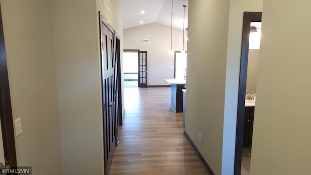 3137 Zuni Way NW, Anoka, MN 55303 - hallway with wood finished floors, high vaulted ceiling, baseboards, and a sink