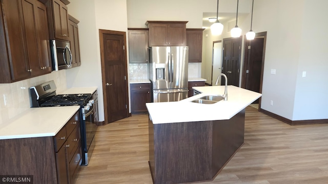 3137 Zuni Way NW, Anoka, MN 55303 - kitchen featuring stainless steel appliances, a sink, light wood-type flooring, and an island with sink
