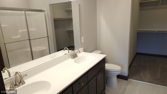 3137 Zuni Way NW, Anoka, MN 55303 - full bathroom with a stall shower, toilet, double vanity, and a spacious closet