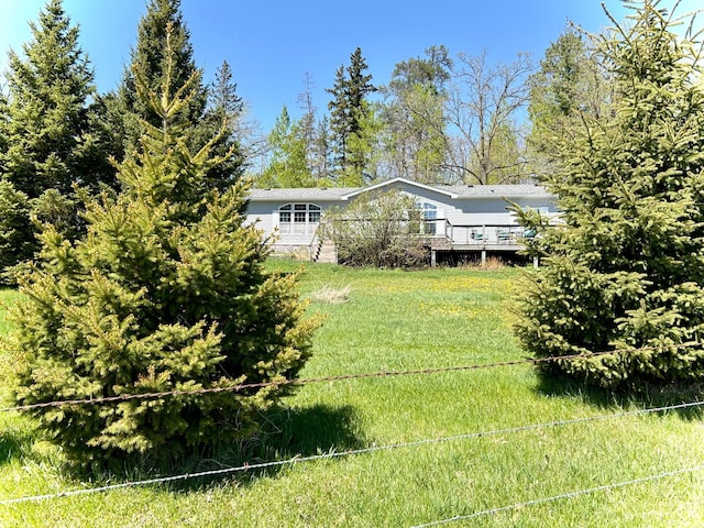view of grassy yard featuring a wooden deck
