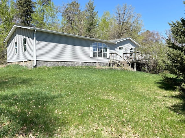 back of property featuring a lawn and a wooden deck