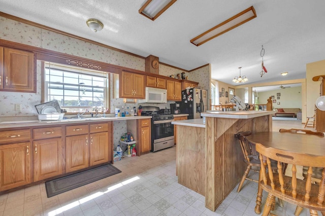 7210 79th Ave SW, Staples, MN 56479 - kitchen featuring stainless steel appliances, wallpapered walls, light countertops, brown cabinetry, and lofted ceiling