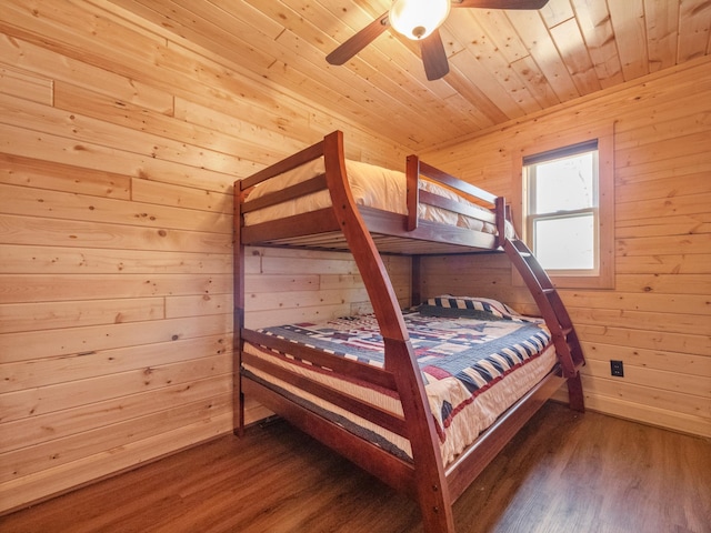 bedroom with wood walls, wood finished floors, wooden ceiling, and ceiling fan