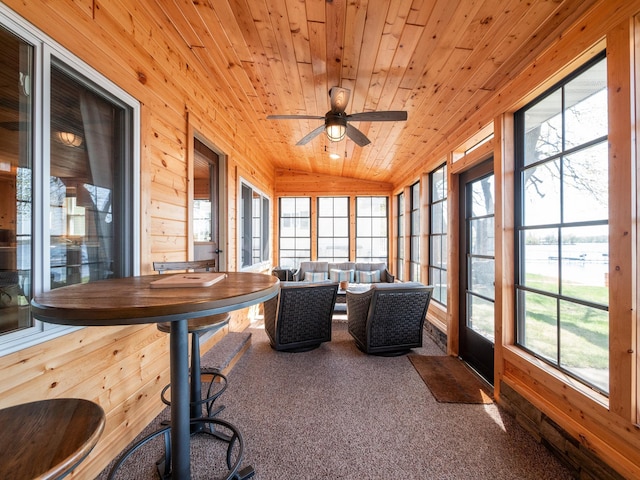 sunroom / solarium with wooden ceiling, carpet, healthy amount of natural light, and wooden walls
