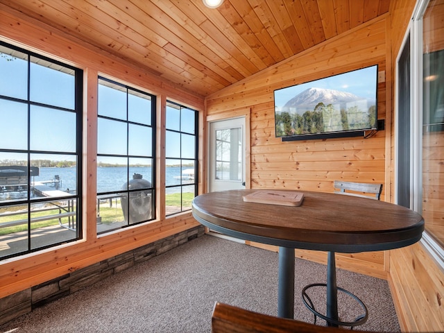 sunroom / solarium featuring wood walls, vaulted ceiling, carpet, and wooden ceiling