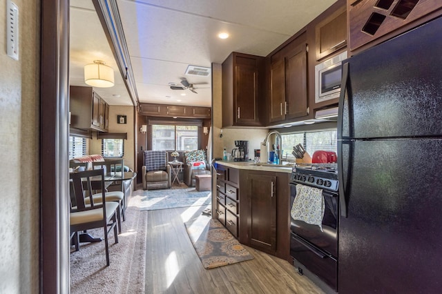 21588 Gull Lake Loop Rd NE Unit 83, Hagali Twp, MN 56683 - kitchen with black appliances, light wood-type flooring, a sink, light countertops, and dark brown cabinets