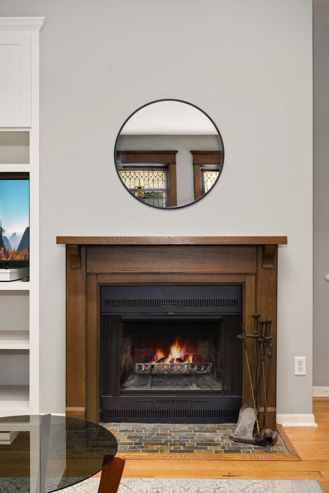 635 Grand Ave Unit 4, Saint Paul, MN 55105 - detailed view of wood finished floors, a lit fireplace, and baseboards