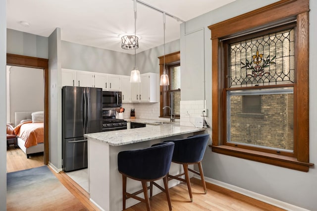 635 Grand Ave Unit 4, Saint Paul, MN 55105 - kitchen featuring freestanding refrigerator, range with gas stovetop, a sink, light wood-style floors, and a peninsula