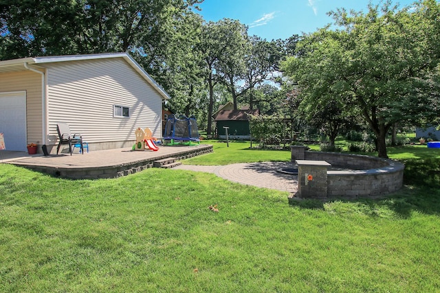 340 5th Ave SW, Hutchinson, MN 55350 - view of green lawn with a trampoline and a patio