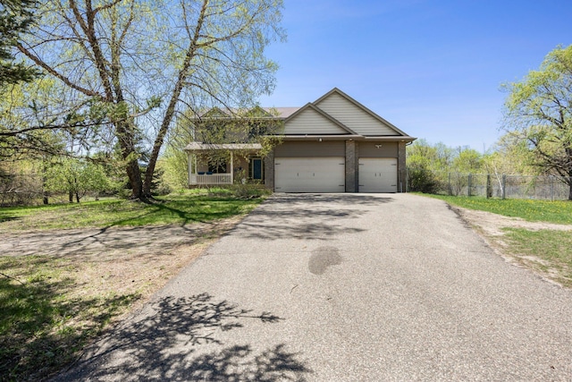 25100 Lincoln Dr NE, Athens Twp, MN 55040 - view of front of home featuring fence, asphalt driveway, a garage, and brick siding