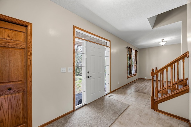 25100 Lincoln Dr NE, Athens Twp, MN 55040 - foyer entrance with stairs, baseboards, light tile patterned flooring, and a textured ceiling